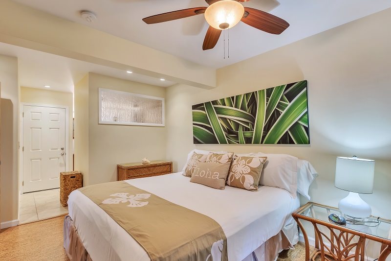 Luxury bedding with Hawaiian design pillows on a queen size bed inside a Maui vacation rental condo